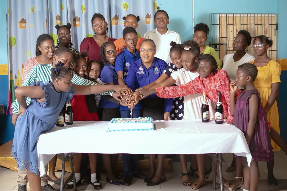 Missionaries and children gathered around a celebration cake