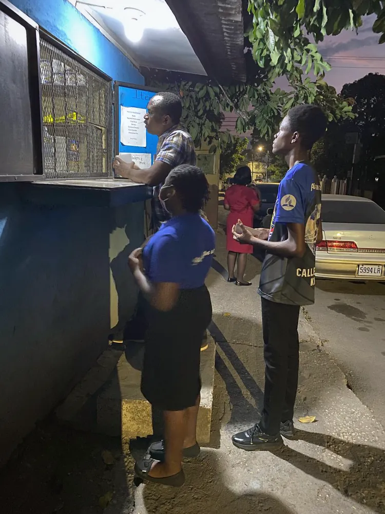 Missionaries speaking with people at a shop window in the evening